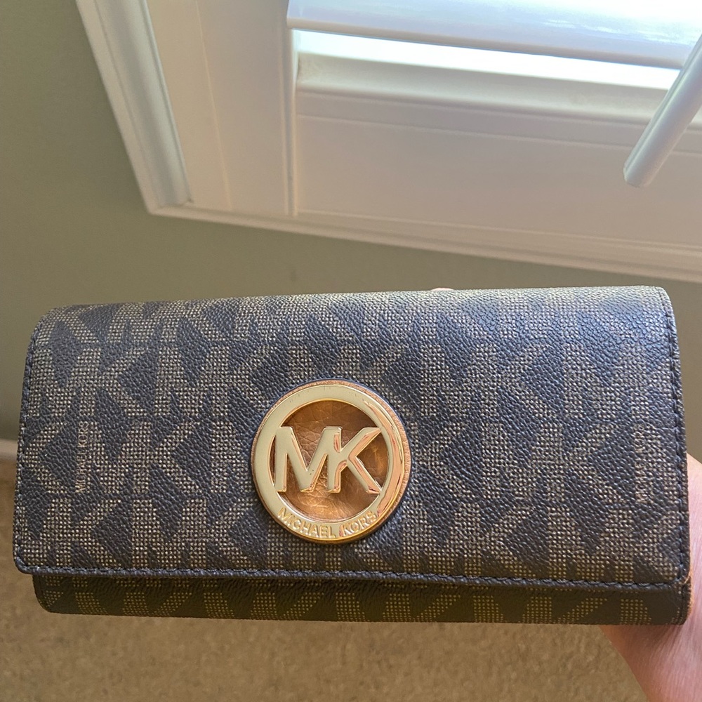 Michael Kors signature wallet with gold emblem.
